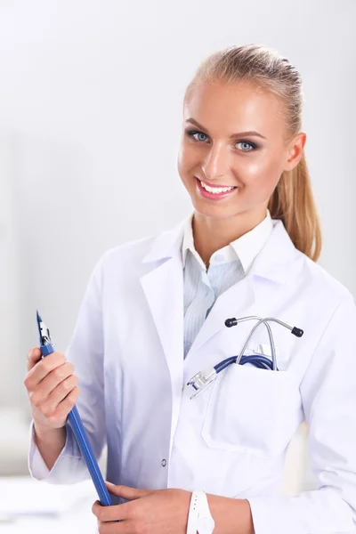 Smiling female doctor with a folder in uniform standing at hospital — Stock Photo, Image