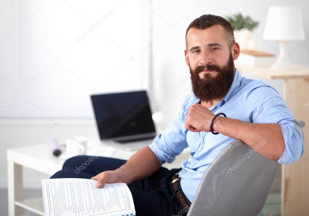 Sandalye ile office kitapta oturan genç işadamı — Stok Foto ©