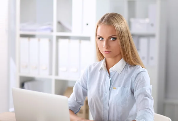 Attraente donna d'affari seduta su una scrivania con computer portatile in ufficio — Foto Stock