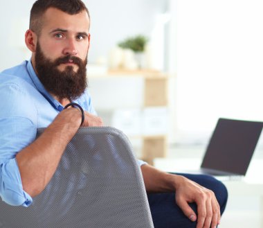 sandalye ile office kitapta oturan genç işadamı