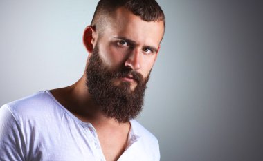 Ayakta, gri arka plan üzerinde izole yakışıklı adam portresi