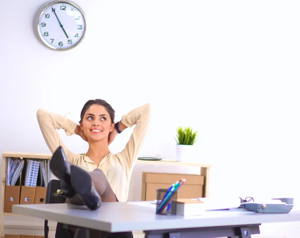 Geschäftsfrau entspannt sich mit den Händen hinter dem Kopf und sitzt auf einem Bürostuhl — Stockfoto