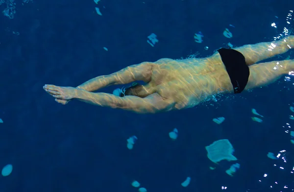 Nuotatore maschile in piscina. Foto subacquea . — Foto Stock