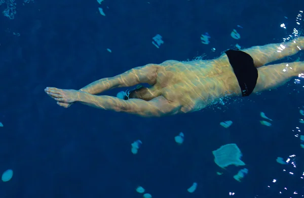 Male swimmer at the swimming pool. Underwater photo. — Stock Photo, Image