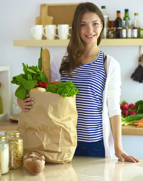 Young woman holding grocery shopping bag with vegetables — Stock Photo, Image