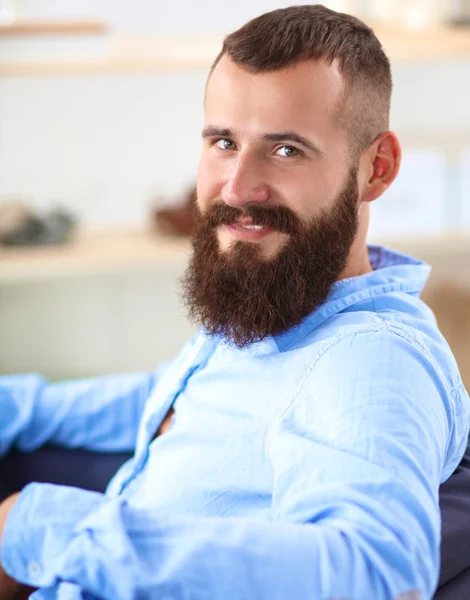 Jonge zakenman zit op stoel in functie — Stockfoto