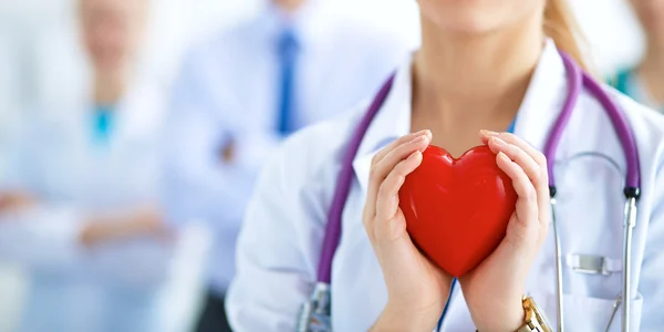 Doctora con estetoscopio que sostiene el corazón — Foto de Stock