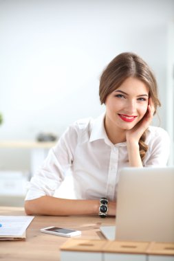 Ofiste masa başında oturan çekici bir iş kadını.