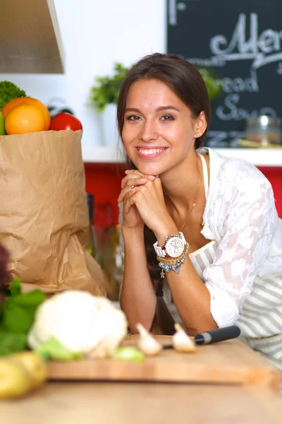 Young woman standing near desk in the kitchen — Stock Photo, Image