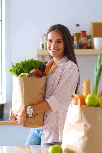 Jeune femme tenant sac d'épicerie avec des légumes — Photo