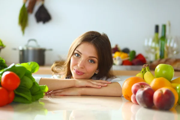 Young woman sitting near desk in the kitchen — Stock Photo, Image