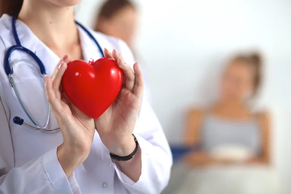 Female doctor with stethoscope holding heart — Stock Photo, Image