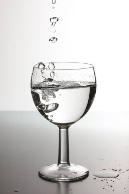 Su damlaları bir bardak içme suyuna dökülüyor. Güzel bir damla su..