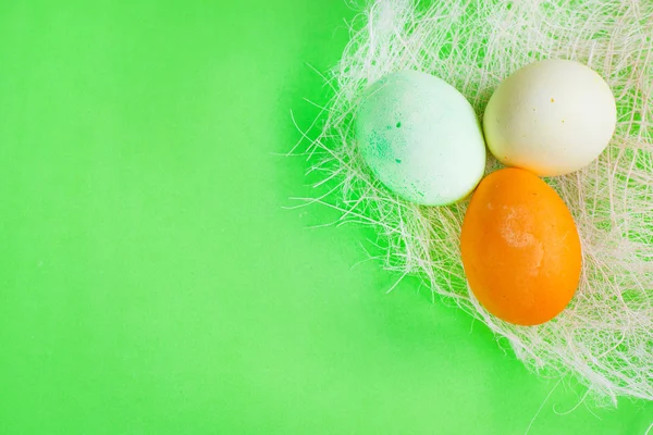 Tre gröna, gula och orange ägg påsk bakgrund — Stockfoto