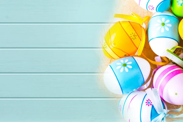 Vibrant holiday colorful Easter eggs on turquoise wooden planks background — Stock Photo, Image