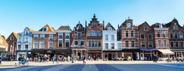 Delft, Hollanda 'da evleri ve insanları olan renkli sokak manzarası