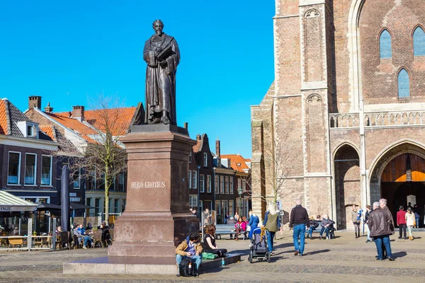 Statue of Hugo Grotius, New Church entrance, people in Delft, Holland