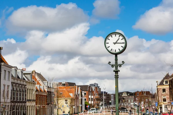 Horloge de rue, maisons traditionnelles, ciel bleu nuageux — Photo