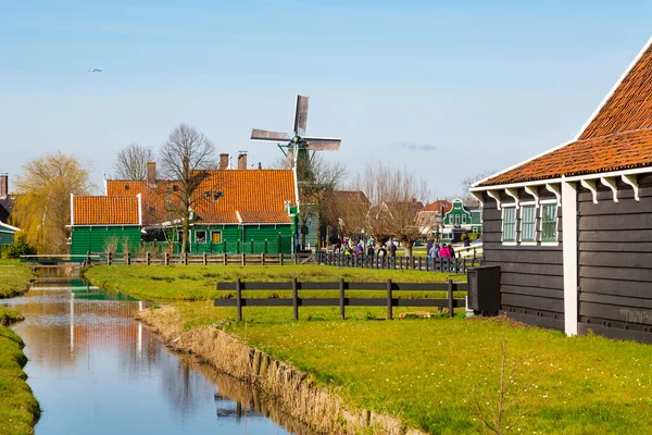 Zaanse Schans byn, Holland, växthus och väderkvarnar mot blå molnig himmel — Stockfoto