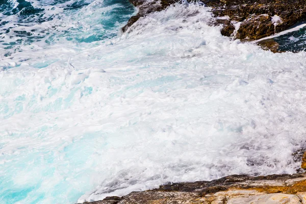 Imagem de fundo de espuma e ondas na praia de pedra — Fotografia de Stock