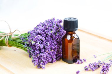 Taze lavanta çiçekleri ve ahşap arka planda yağ.