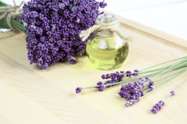 Taze lavanta çiçekleri ve ahşap arka planda yağ.