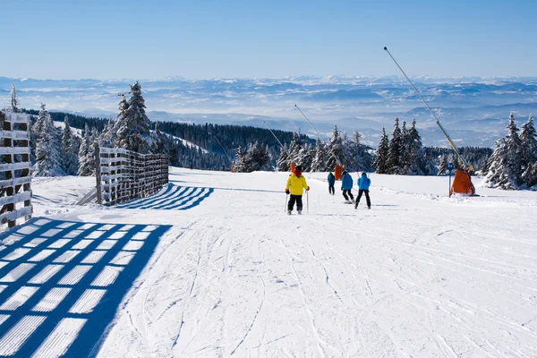 Skipiste, Skifahrer den Berg hinunter, Blick auf die Berge — Stockfoto