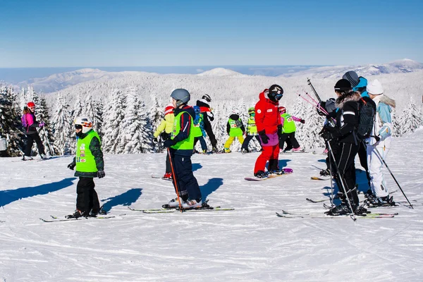 Лыжный склон, люди катаются на лыжах с холма, вид на горы — стоковое фото