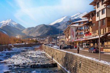 Bansko, Bulgaristan - 28 Ocak 2021: Glazne nehri, Bulgar kenti, otel evleri ve kar Pireni dağlarının zirveleri