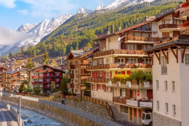 Zermatt, İsviçre - 7 Ekim 2019: Geleneksel ahşap evler, alp köyü sonbahar panoraması, İsviçre Alpleri, nehir ve kar dağları manzarası