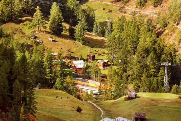 Çam ormanlarındaki güzel alp köyü, İsviçre, Zermatt yakınlarındaki İsviçre Alpleri ve teleferik kulübeleri.