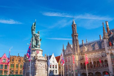 Bruges, Belçika - 10 Nisan 2016: Jan Breydel ve Pieter de Coninck 'in heykeli ve Pazar Meydanı Markt' ta Brugge bayrağı