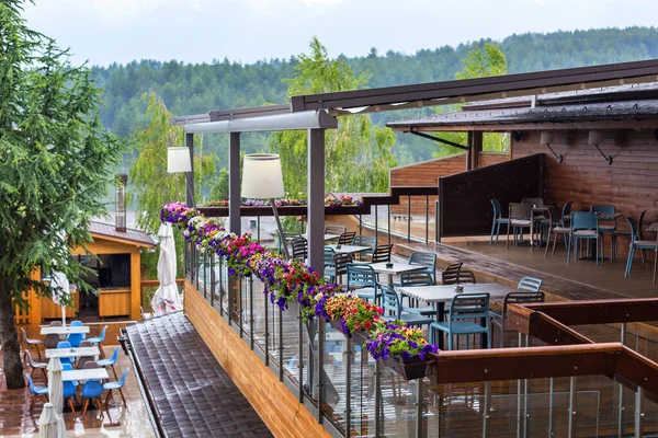 Tisch und Stühle im Terrassencafé, Regen — Stockfoto