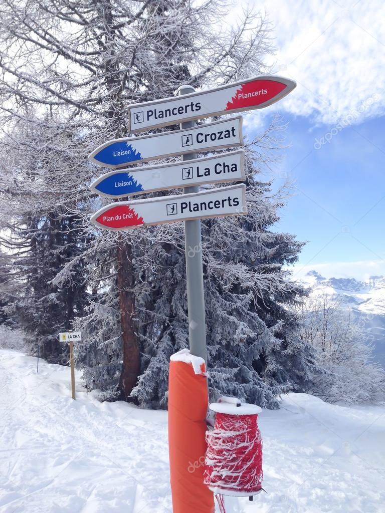 Signpost giving directions to different ski slopes