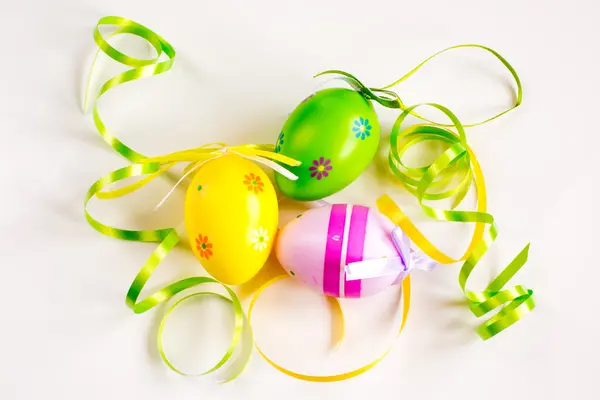 Три пасхальных яйца, зеленые и желтые ленты — стоковое фото
