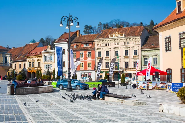 People feeding the pigeons at Council Square in downtown of Brasov, Romania. — Stock Photo, Image