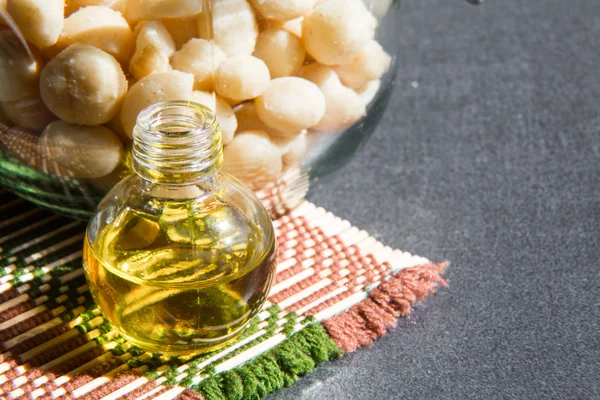 Still life with Macadamia oil in the bottle and nuts — Stock Photo, Image