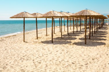 Satır kumsal, deniz ve mavi gökyüzü ahşap şemsiye