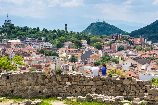 Pareja sentada en la muralla de la fortaleza y mirando la vista de la ciudad de Plovdiv, Bulgaria —  Fotos de Stock
