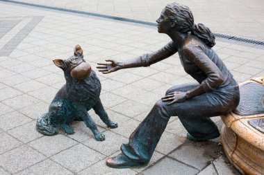 Bir kız köpeğini yanında nehir Tuna ile oynamaktan bronz heykeli.