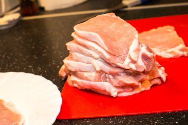 Dilimlenmiş çiğ et parçaları kırmızı kartı üzerindeki yığını