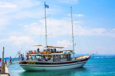 Turistler Ouranoupoli bağlantı noktası Köyü, Yunanistan Yunan bayrağı altında gemisinden iner