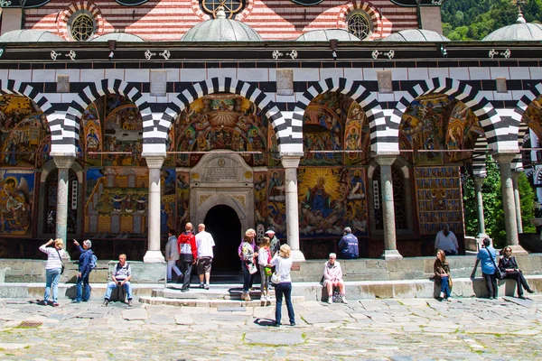 Turistas cerca de la iglesia en el famoso Monasterio de Rila, Bulgaria — Foto de Stock