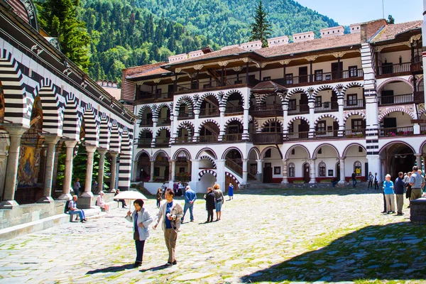 Turistas cerca de la iglesia en el famoso Monasterio de Rila, Bulgaria — Foto de Stock