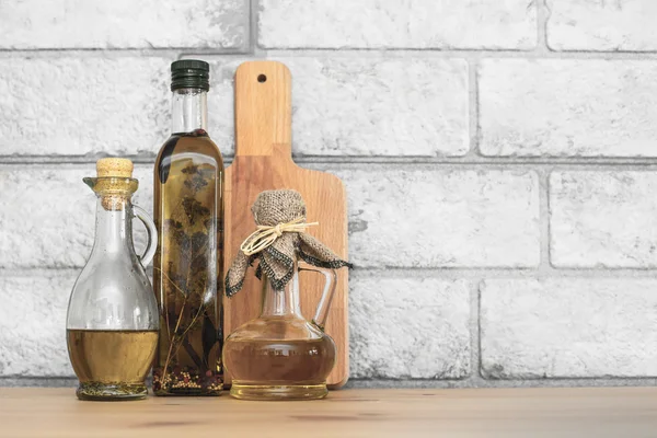 Three bottles of Olive oil on grey bricks background