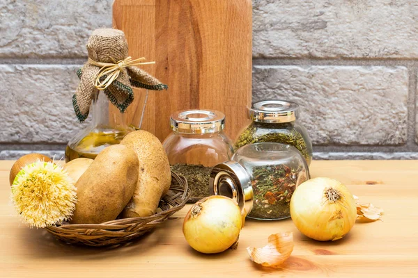 Brocca di olio d'oliva, patate, cipolla, tagliere e spezie nei barattoli — Foto Stock