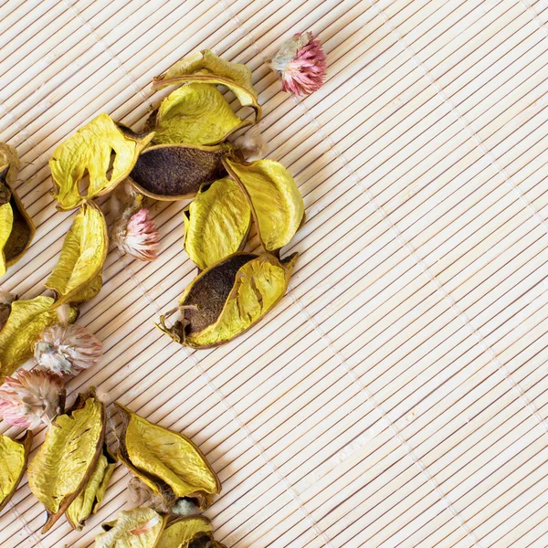 Pétalos de flor seca sobre fondo de estera de bambú —  Fotos de Stock