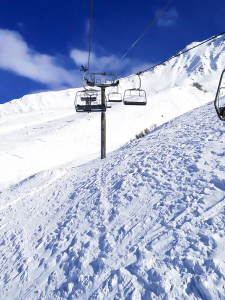 Cadeiras teleférico e pistas de esqui nas montanhas — Fotografia de Stock