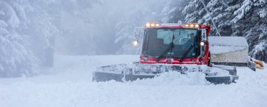 Bansko, Bulgaristan - 21 Ocak 2024: Kar temizleyici kar temizleme pisti makinesi kayak yolu yamacını alp kayağı ve kış tatil beldesi için hazırlıyor