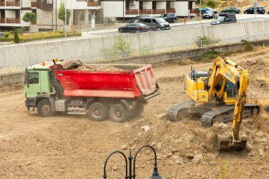 Bansko, Bulgaristan - 25 Eylül 2025: Sanayi kazıcısı bir çöp kamyonuna toprak yüklüyor